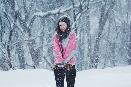 woman standing on snow field near trees at daytime thumbnail