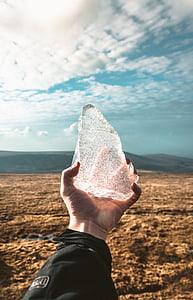 person holding clear stone thumbnail