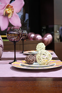 black long-stemmed wine glass beside round ceramic plate with three brown and beige wire balls thumbnail