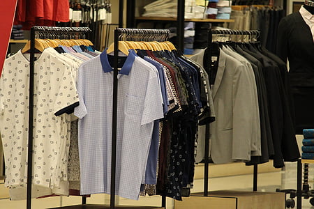 shirt and suit jacket hanging on store racks thumbnail