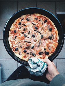 person holding pan of pizza thumbnail