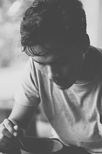Gray Scale Photo of Man Eating thumbnail
