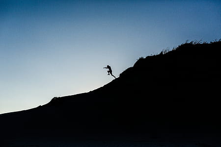 silhouette of person running down of the hill thumbnail