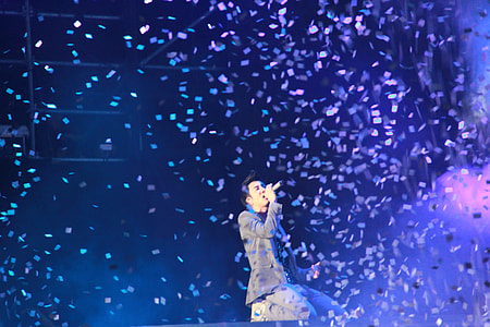 time lapse photography of man singing on stage with confetti thumbnail