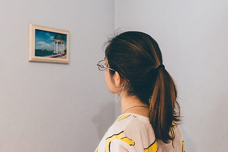 woman looking at picture on wall thumbnail