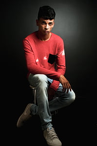 man wearing red sweatshirt sitting on chair thumbnail