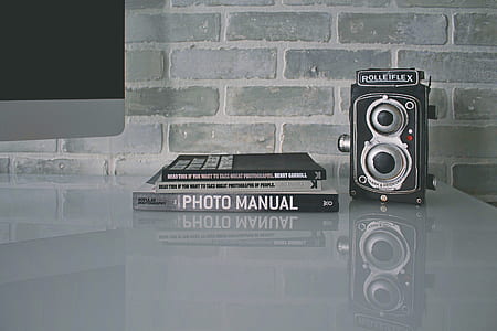 Photo manual beside black and gray vintage camera thumbnail
