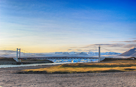 gray and white concrete bridge across the body of water thumbnail