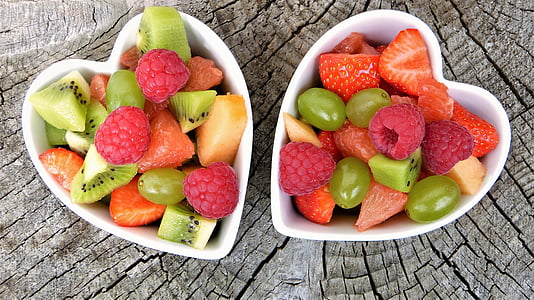 sliced fruits inside white ceramic heart-shaped bowls thumbnail
