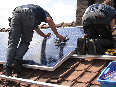man putting solar panel board on roof during daytime thumbnail