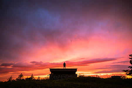 man standing on building during sunset thumbnail