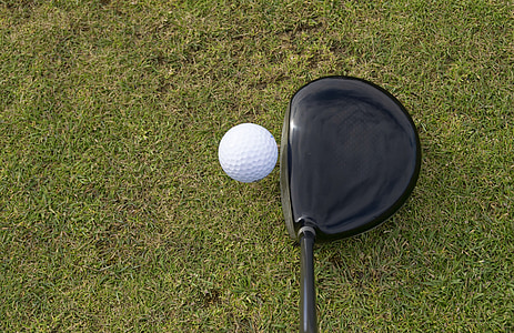 white golf ball beside black driver thumbnail