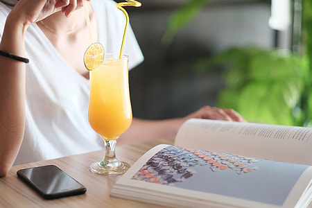 woman sitting on chair facing table with book and glass thumbnail