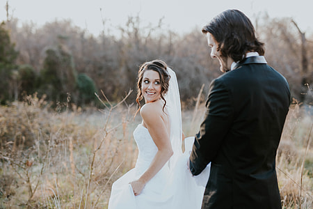 groom and bride standing on brown grass field at daytime thumbnail