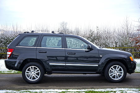 close-up photography of black Jeep Grand Cherokee SUV on concrete road thumbnail