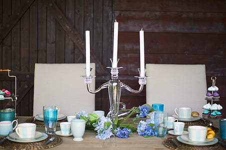 clear glass candle holder on top of table near cup and saucers thumbnail