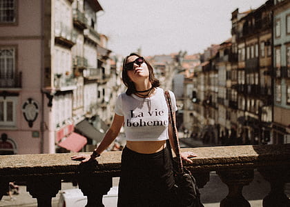woman wearing white and black crop-top standing near brown concrete balustrade thumbnail
