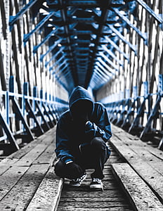 man wearing blue hoodie and black pants in bridge photography thumbnail