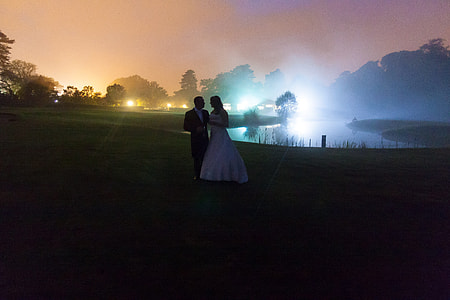 couple walking near body of water during nighttime thumbnail