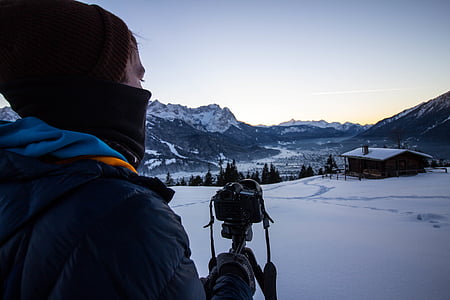 person taking photo of house on snowfield thumbnail