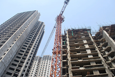 low angle photography of tower crane near buildings thumbnail