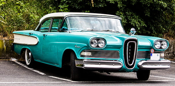 teal and white sedan parked in parking lot thumbnail