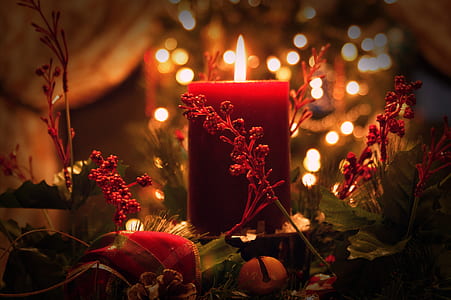 red pillar candle surrounded by artificial plant decor thumbnail