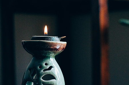 shallow focus photography of teal ceramic candle burner thumbnail