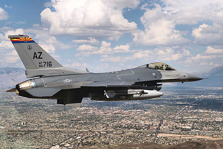 gray jet plane on air under white clouds and blue sky thumbnail