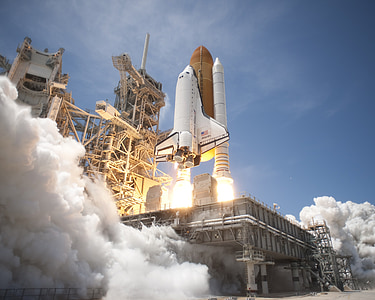 white and brown space shuttle launch under blue sky during daytime thumbnail