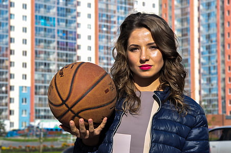 woman wearing dark-blue down jacket holding basketball thumbnail