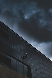 low-angle shot of two person hanging on building thumbnail