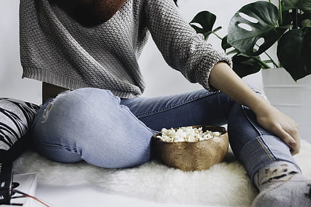 person sitting on white fleece mat beside brown bowl thumbnail