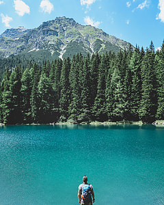 man stands beside body of water during day thumbnail