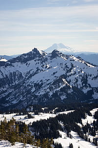 snow covered mountain near trees under white cloudy sky thumbnail