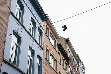 pair of shoes hung on black cable at daytime thumbnail