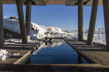 man and woman bathing in pool with mountain alps view thumbnail