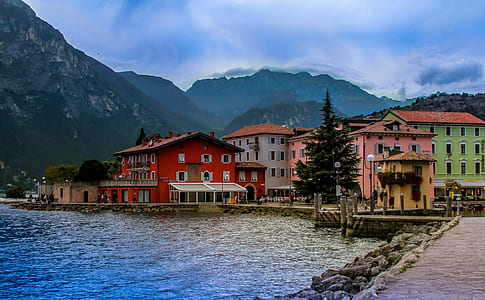 buildings near body of water and mountains thumbnail