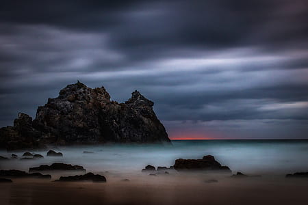 island surrounded by body of water under grey clouds thumbnail