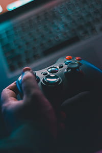selective focus photography of person holding black Xbox 360 controller thumbnail