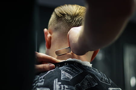 person shaving man's head using straight razor thumbnail