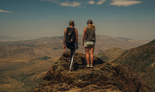 man and woman standing on rock formation of grand canyon during daytime thumbnail