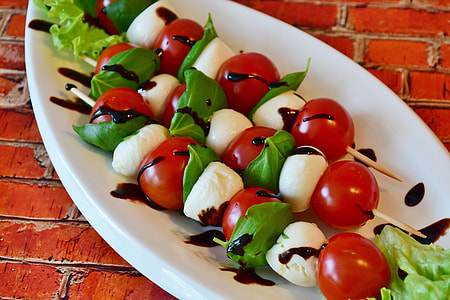 closeup photo of white oval plate of vegetable skewers thumbnail