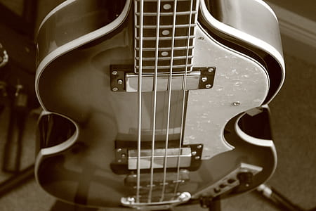 focus photo of brown and white electric bass guitar thumbnail
