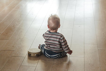 boy's white and black striped long-sleeved shirt sits near tambourine thumbnail