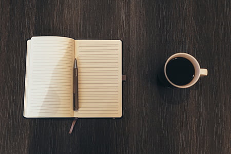 gray pen on notebook beside mug thumbnail