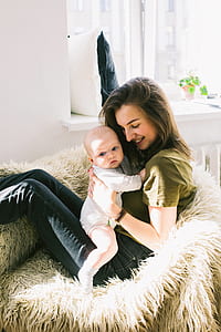 Woman in Green Shirt Holding Baby While Sitting thumbnail