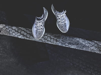 person standing wearing pair of white-and-black Adidas mid-top sneakers thumbnail