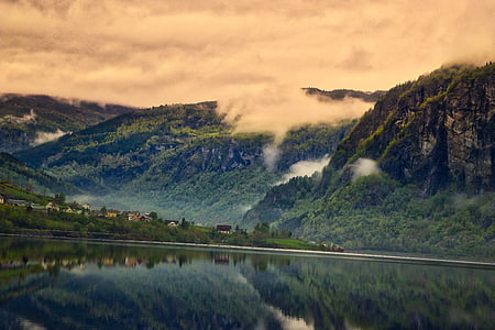 body of water under mountain photography thumbnail
