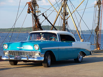 vintage blue car near blue ocean water during daytime thumbnail